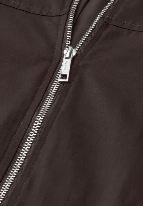 Nahaufnahme eines silbernen Reißverschlusses auf schwarzem Stoff.
