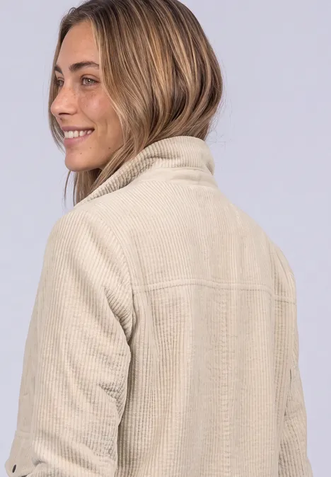 Cordjacke mit Hemdkragen und Zipper clay sand Junge Frau in einem beigen Cord- oder Fleece-Jacke, blickt über die Schulter und lächelt.