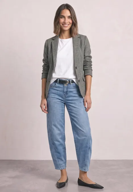 Eenvoudige blazer met reverskraag en patroon Black Eine lächelnde Frau trägt graues Sakko, weißes T-Shirt, blaue Jeans und schwarze Ballerinas vor hellem Hintergrund.