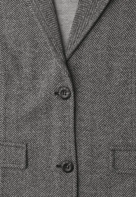 Eenvoudige blazer met reverskraag en patroon Black Nahaufnahme eines grauen Herringbone-Blazers mit zwei Knöpfen und Einschubtaschen.