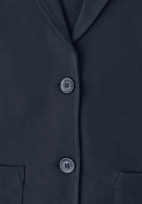 Nahaufnahme eines dunkelblauen Blazers mit Revers, zwei Knöpfen und zwei Pattentaschen.