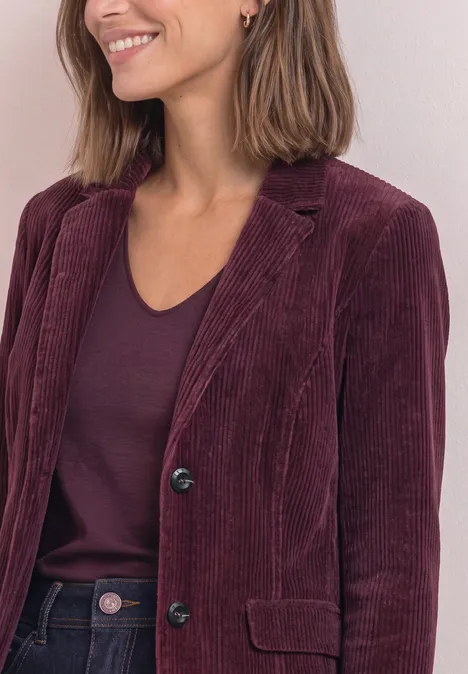 Femme souriante en veste velours côtelé bordeaux