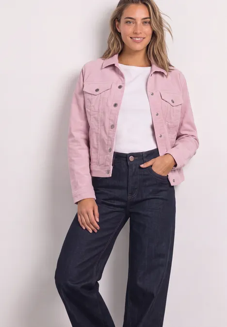 Jacke aus Cord mit Knopfleiste quiet rose Eine lächelnde Frau trägt eine rosa Jacke, weißes Top und dunkle Jeans, steht vor hellgrauer Wand.