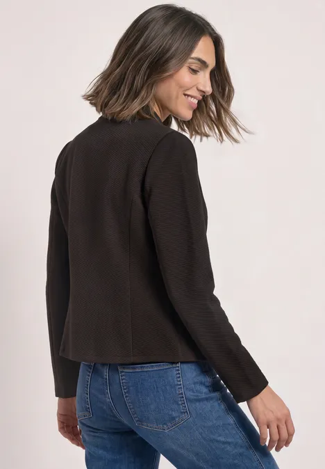 Blazer aus Jersey mit Struktur black coffee Eine lächelnde Frau in dunkelbrauner Jacke und blauer Jeans, die über die Schulter blickt.