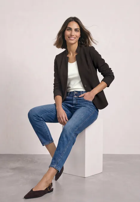 Blazer aus Jersey mit Struktur black coffee Eine Frau in Jeans, weißem Top und dunkelblauem Blazer sitzt lässig auf einem Würfel und lächelt.
