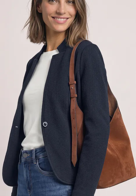 Blazer van jersey met structuur darkest blue Een glimlachende vrouw in jeans, wit shirt en donkerblauw jasje draagt een bruine tas.