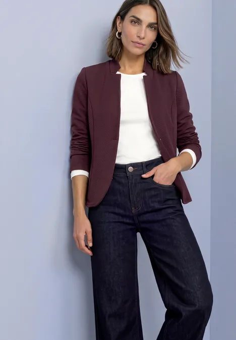 Blazer van jersey met structuur berry plum Vrouw in bordeauxblazer, wit shirt en wijde jeans, poserend voor een effen achtergrond.
