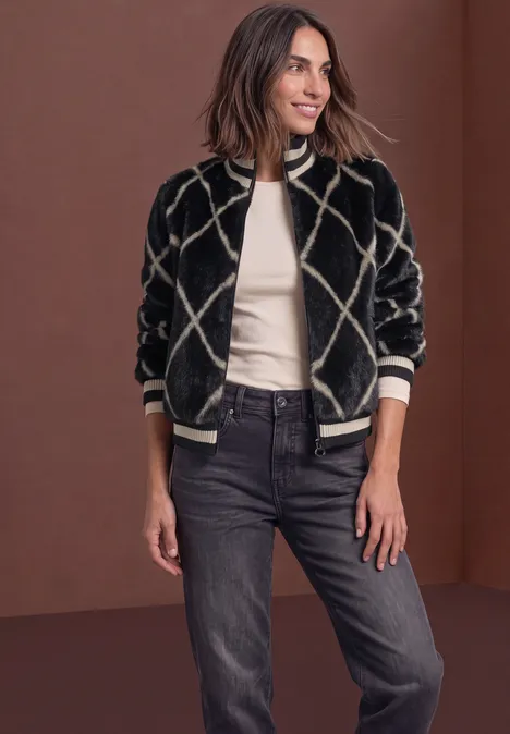 Fake Fur Blouson mit Leder-Look-Details armor grey Eine Frau trägt eine schwarz-beige Bomberjacke mit Rautenmuster, weiße Bluse und schwarze Jeans.