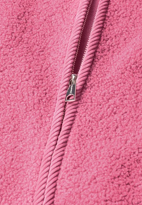 Nahaufnahme eines rosafarbenen Fleece-Stoffs mit mittigem Reißverschluss.