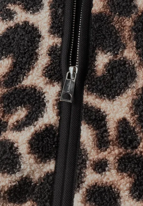 Nahaufnahme eines Leopardenmusters mit schwarzem Reißverschluss auf flauschigem Stoff.