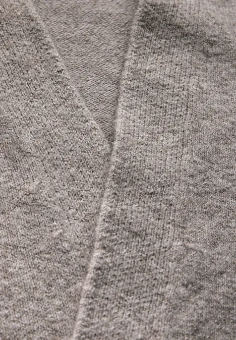 Nahaufnahme eines grauen Strickpullovers.