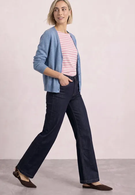Cardigan à col en V et patte de boutonnage northern blue mel. Femme portant un gilet bleu, un T-shirt rayé rose et un jean large foncé, marchant d'un pas décontracté.