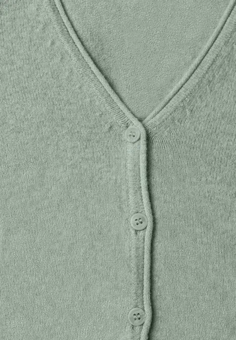 Cardigan à col en V et patte de boutonnage eucalyptus green mel. Gros plan d'un cardigan vert en maille duveteuse avec col en V et trois boutons.