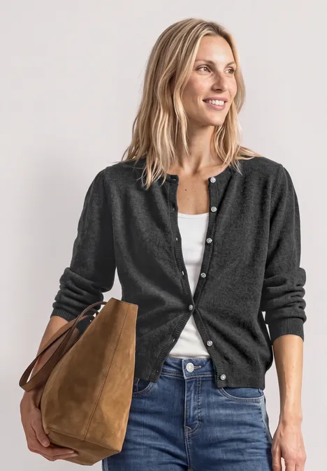 Langarm Cardigan mit Rundhals und Knöpfen armor grey mel. Frau in Jeans, weißem Top und dunklem Cardigan, trägt eine braune Tasche, lächelt entspannt.
