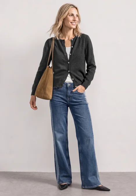Langarm Cardigan mit Rundhals und Knöpfen armor grey mel. Eine Frau trägt schwarze Strickjacke, weite Jeans, flache Schuhe und eine braune Tasche.