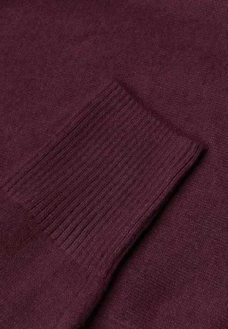 Langarm Cardigan im offenen Schnitt rustic rouge Nahaufnahme eines weinroten Strickpulloverärmels mit Rippenstrickbündchen.