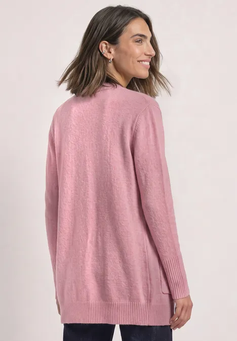 Femme en long gilet maille rose avec poches, vue de dos sur fond clair.