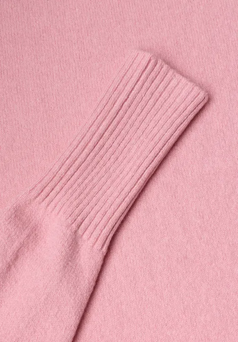 Gros plan sur un vêtement en tricot rose avec un bord-côte.