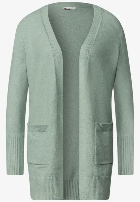 Gilet en maille vert pâle, ouvert devant, manches longues, avec deux poches plaquées.