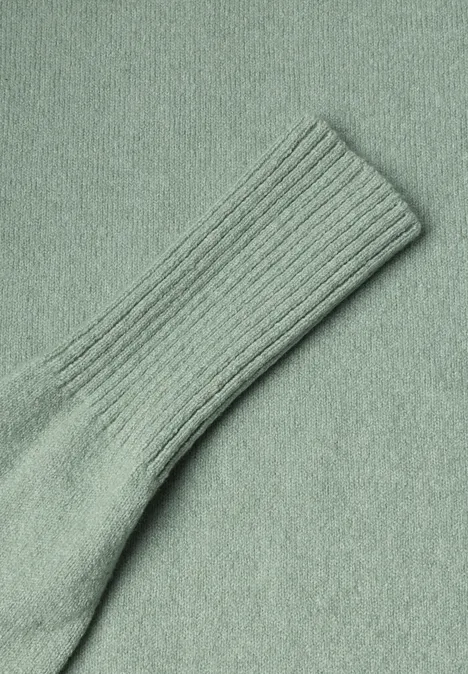 Gros plan sur une chaussette en maille vert clair côtelée en tissu doux.