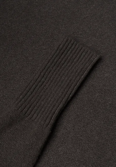 Un pull noir avec bord-côte au niveau de la manche.