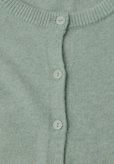 Nahaufnahme eines pastellgrünen Strickcardigans mit drei Knöpfen.