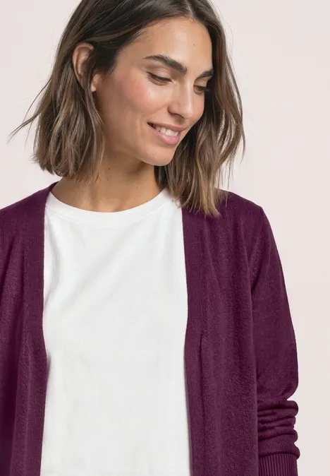 Offener Cardigan in Unifarbe berry maroon Eine lächelnde Frau mit kurzem braunen Haar trägt weißes Shirt und lila Cardigan.