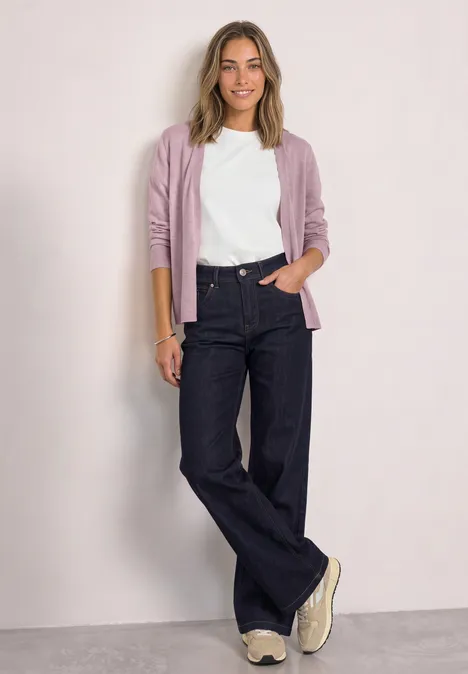 Offener Cardigan in Unifarbe quiet rose mel. Lächelnde Frau mit lila Cardigan, weißem Shirt und weiten Jeans vor hellem Hintergrund.