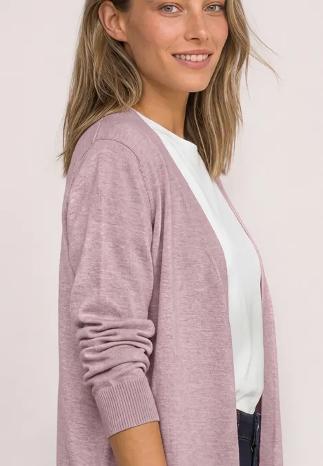 Offener Cardigan in Unifarbe quiet rose mel. Eine junge Frau lächelt und trägt eine leichte roséfarbene Strickjacke über einem weißen Shirt.