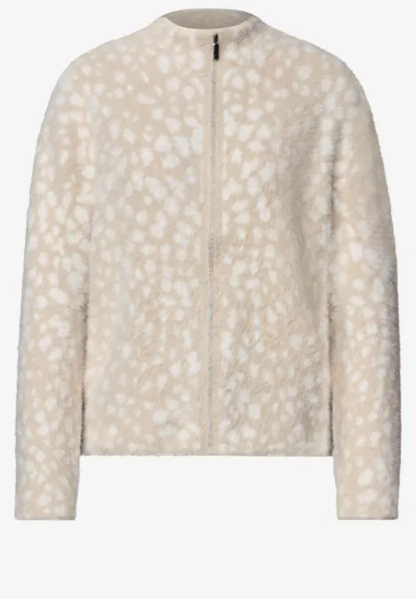 Lichtbeige teddyjas met ritssluiting, lange mouwen en subtiele witte vlekken.