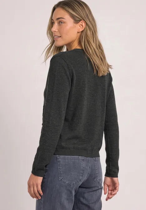 Vest met ronde hals en ruches armor grey mel. Vrouw in donkergrijze trui en blauwe jeans, schuin van achter gefotografeerd, ontspannen uitstraling