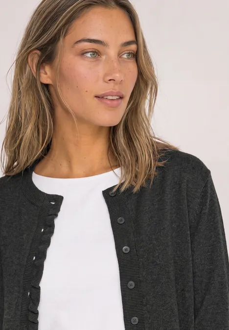 Vest met ronde hals en ruches armor grey mel. Vrouw met bruin haar draagt witte top en zwarte cardigan en kijkt opzij.