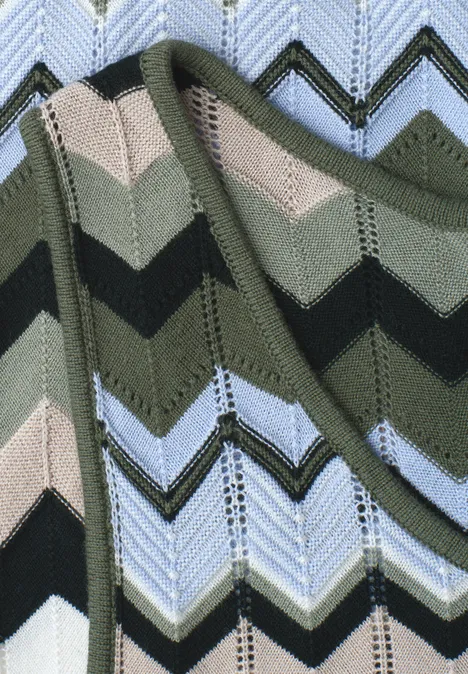 Gebreide stof met zigzagpatroon in groen-, beige-, zwart- en blauwtinten.
