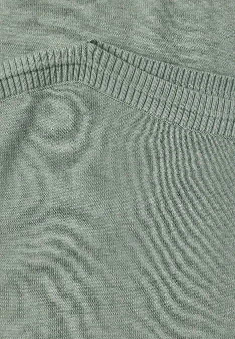 Eenvoudige trui met boothals eucalyptus green mel. Nahaufnahme eines grünen Strickpullovers mit sichtbarer Naht und weichem Stoff.
