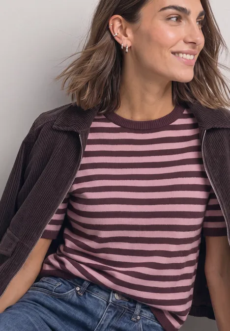 T-shirt met korte mouwen, ronde hals en strepen rustic rouge mel. Frau in braun-rosa gestreiftem Shirt und Jacke lächelt seitlich.