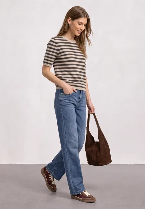 T-shirt met korte mouwen, ronde hals en strepen clay sand mel. Frau trägt gestreiftes T-Shirt, weite Jeans, braune Schuhe und eine passende Tasche auf hellem Hintergrund.