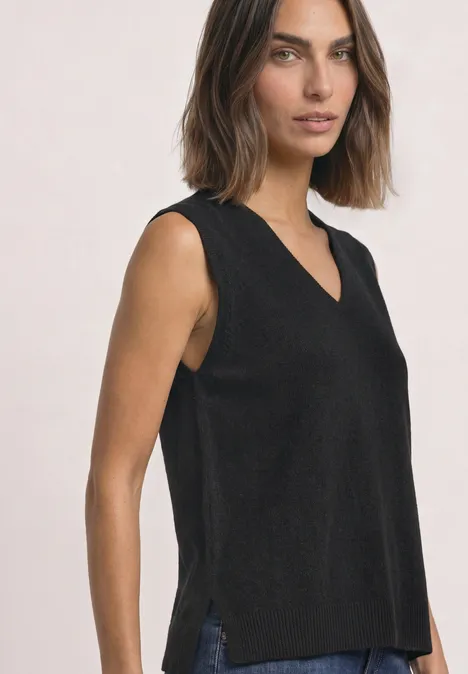 Pullunder mit V-Neck in Unifarbe Black Damenmodel trägt ärmelloses schwarzes V-Ausschnitt-Top mit seitlichen Schlitzen.