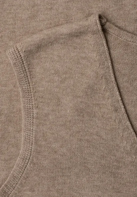 V-hals trui in effen kleur sanded amber mel. Nahaufnahme eines braunen Sweatshirt-Stoffes mit sichtbarem Taschenrand.