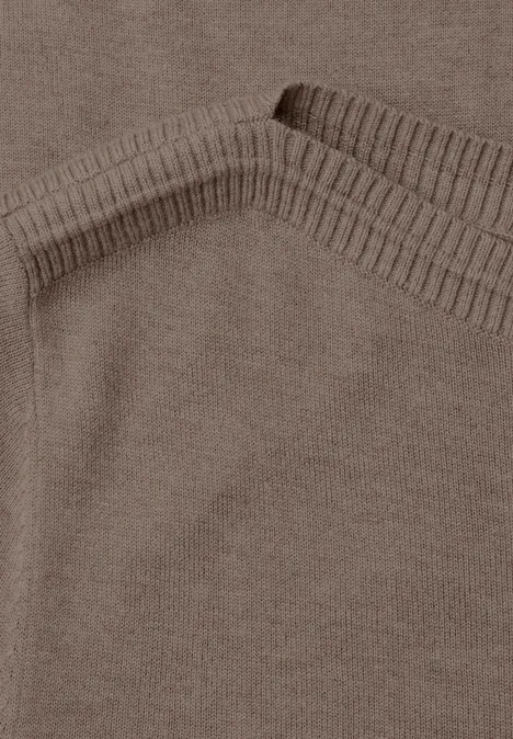 Nahaufnahme eines braunen Strickstoffs mit sichtbarer Rippstrickkante.