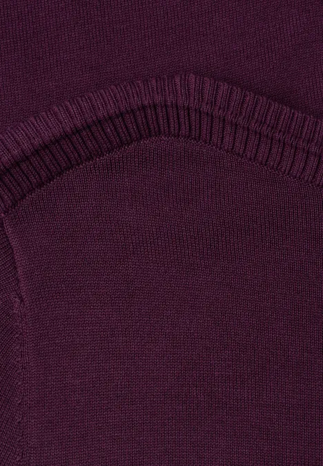 Eenvoudige trui met boothals berry maroon Close-up van een donkerpaarse gebreide stof met een geribbelde boord en zichtbare naad.