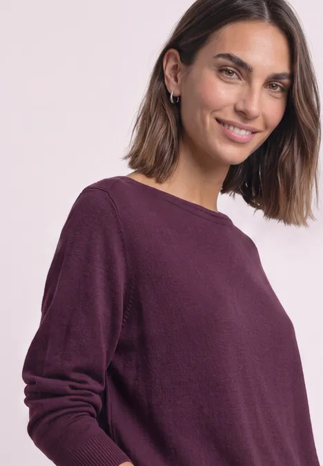 Eenvoudige trui met boothals berry maroon Portret van een glimlachende vrouw in een paarse trui voor een lichte achtergrond.