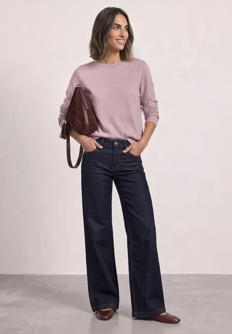 Basic Pullover mit U-Boot-Ausschnitt quiet rose mel. Eine Frau in rosafarbenem Pullover, weiten Jeans und braunen Schuhen mit einer roten Handtasche steht lässig.