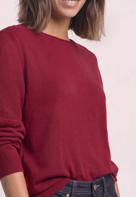 Eenvoudige trui met boothals inferno red Vrouw in rode trui, halflichaam tegen lichte achtergrond.