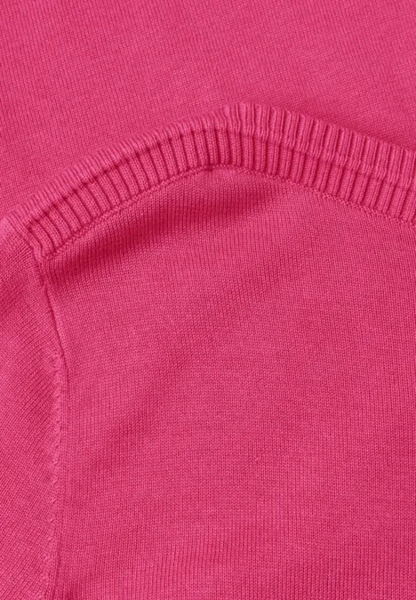 Eenvoudige trui met boothals impact pink Close-up van een roze sweater met opgestikte zak en ribboord.