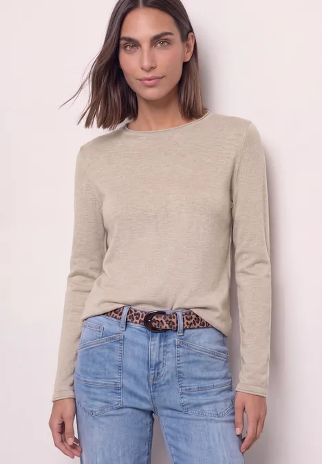 Trui met ronde hals en omgeslagen randen clay sand mel. Een vrouw in een beige trui met lange mouwen, een spijkerbroek en een luipaardriem poseert voor een lichte achtergrond.