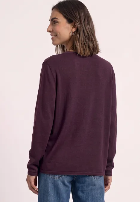 Trui met ronde hals en omgeslagen randen berry maroon Vrouw van achter in blauwe spijkerbroek en donkerpaarse trui met lange mouwen.