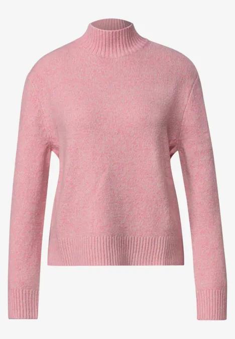 Pull en maille rose à col montant, doux et légèrement ample avec manches longues.