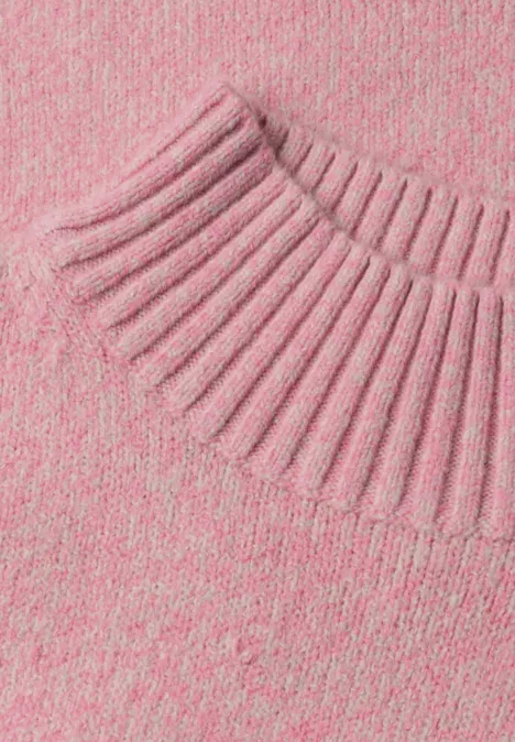 Gros plan d'un pull en maille rose avec col côtelé.