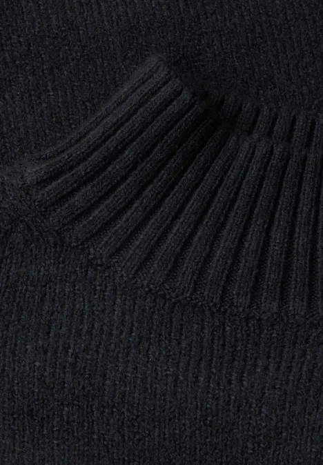 Schwarzer Strickpullover mit geripptem Rollkragen in Nahaufnahme.