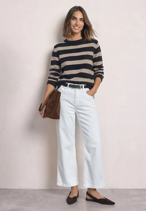 Pullover mit Boat Neck und Streifen indigo night Frau in gestreiftem Pullover, weißen weiten Hosen und schwarzen Schuhen, hält braune Tasche.